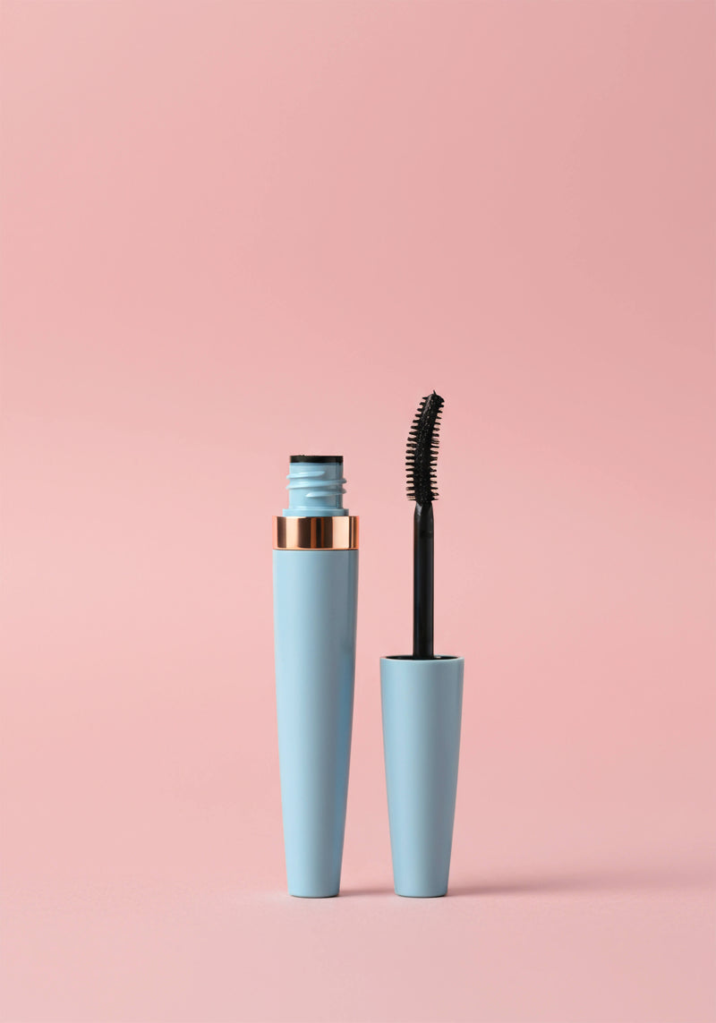 A blue mascara tube with a gold rim. Comes with a standard plastic mascara wand.