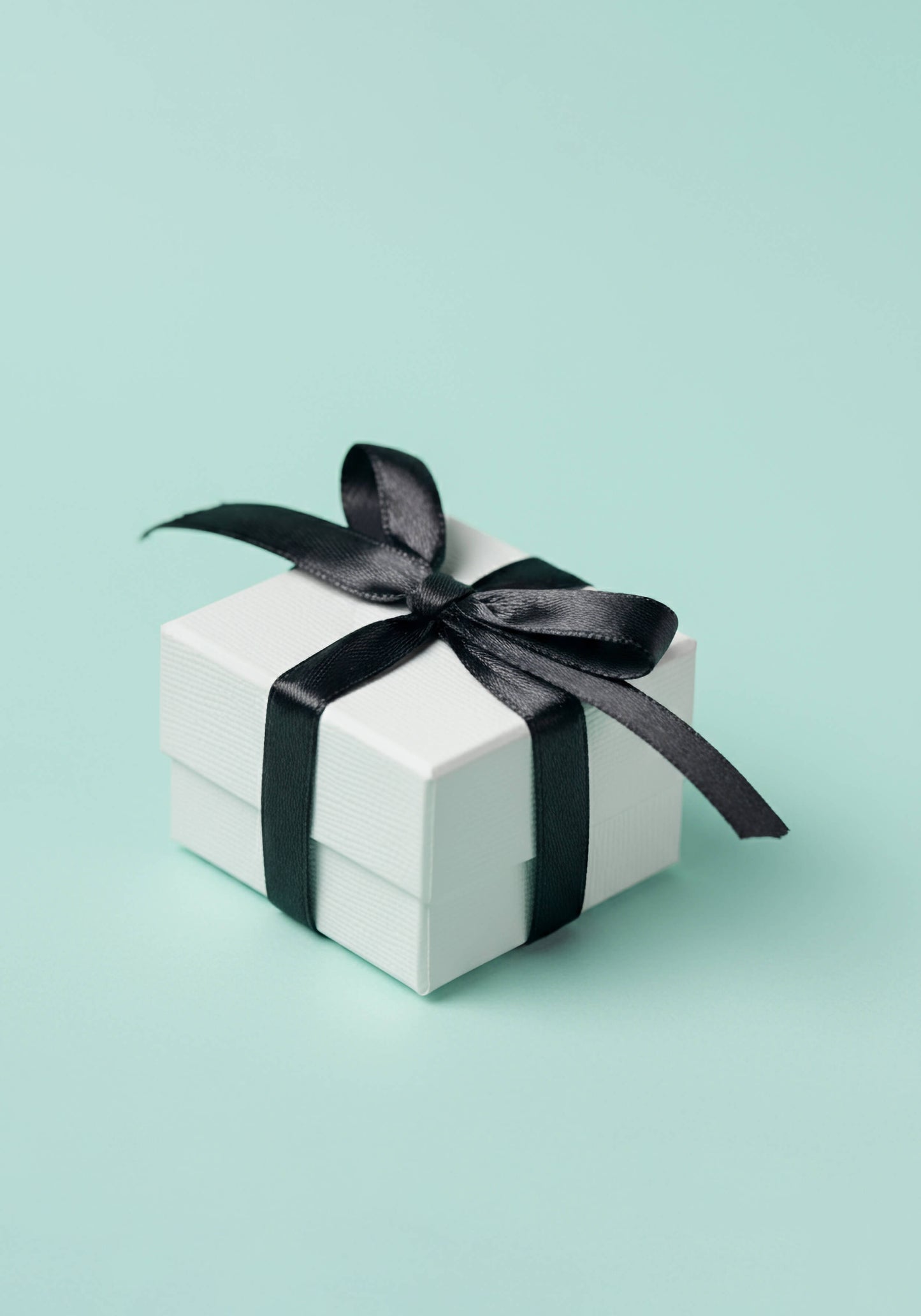 A white gift-wrapped box tied with a black ribbon.