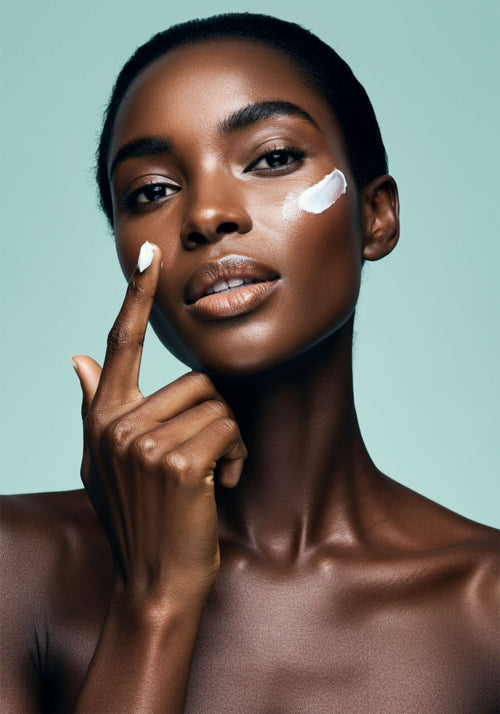 Load image 1 in gallery view. A woman with lowing skin applies a thick moisturizer to her face.